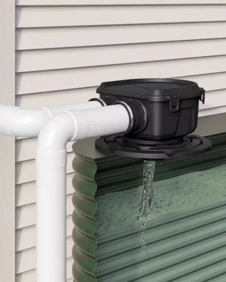 Maelstrom Rainwater harvesting system with a white pipe and black overflow valve attached to a green rain barrel.
