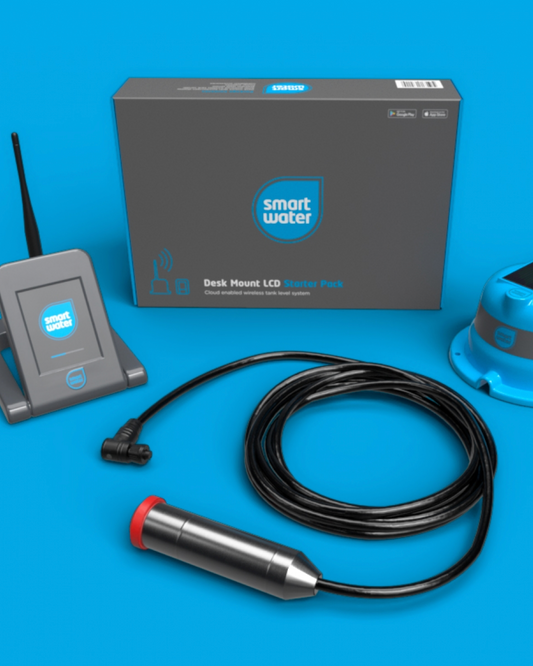Smart Water SW900 Desk Mount Starter Kit with a gray control box, gray wireless controller, blue dome-shaped water level sensor, black cable, and metal probe with red end cap on a blue background.